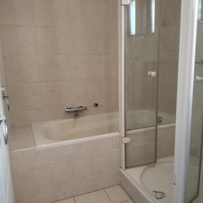 Voor: oude badkamer met ligbad, douchecabine met kwartronde bak en beige tegels