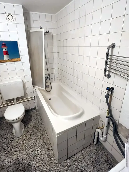 Voor: smalle badkamer met ligbad en staand toilet